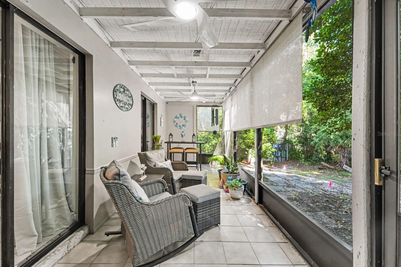 Screened Patio with Wicker Seating Overlooking Lush Landscaping