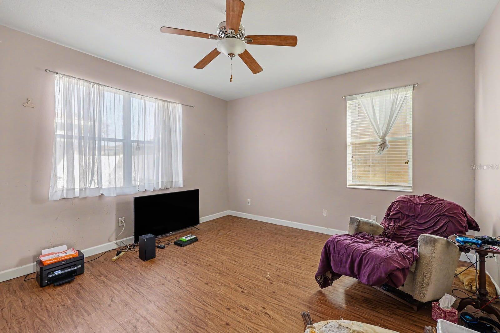 Large Living Space With Wood Floors, Multiple Windows & Ceiling Fan
