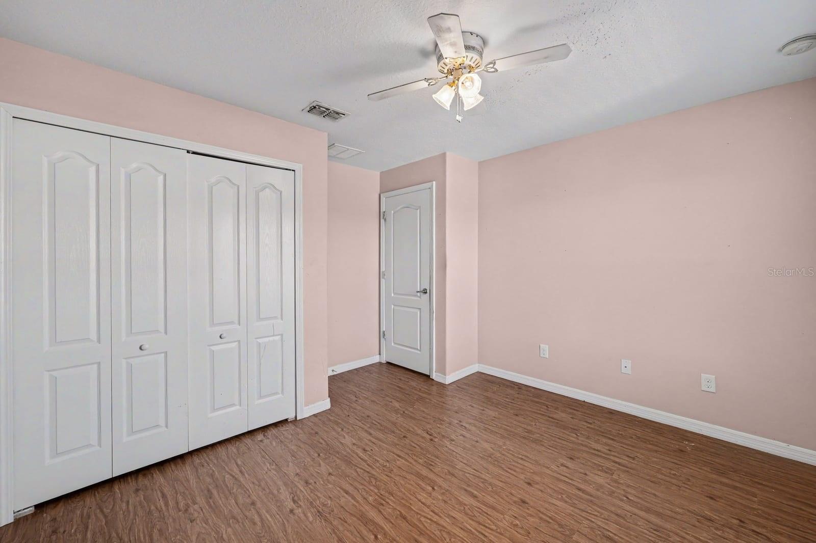 Master Bedroom with Multiple Closets, Windows & Wood Flooring