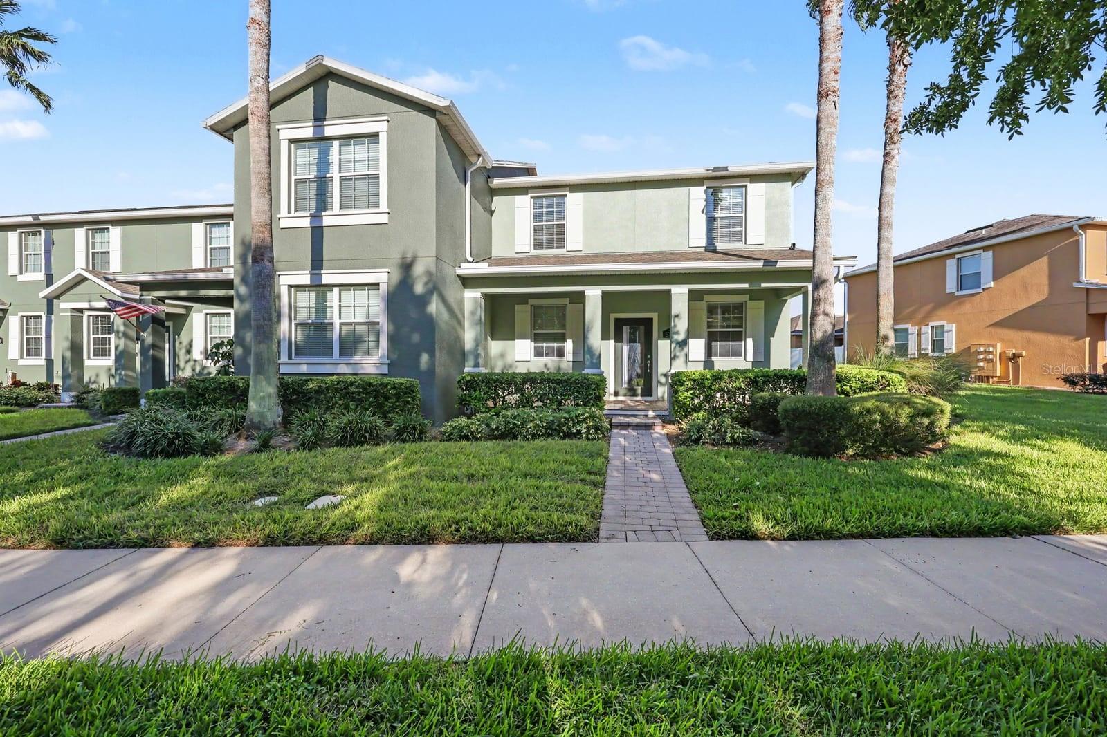 Charming two-story home with green exterior and manicured landscaping Charming two-story home with green exterior and manicured landscaping