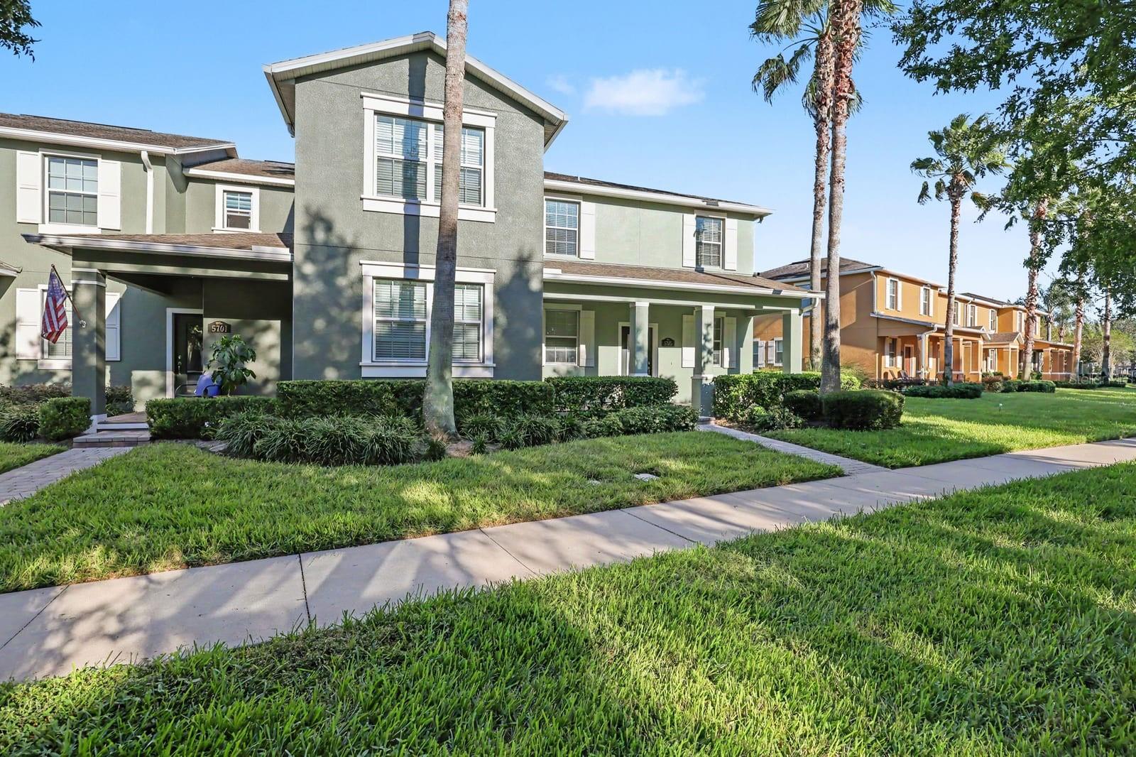 Welcoming front porch and covered entry with palm tree-lined setting Welcoming front porch and covered entry with palm tree-lined setting