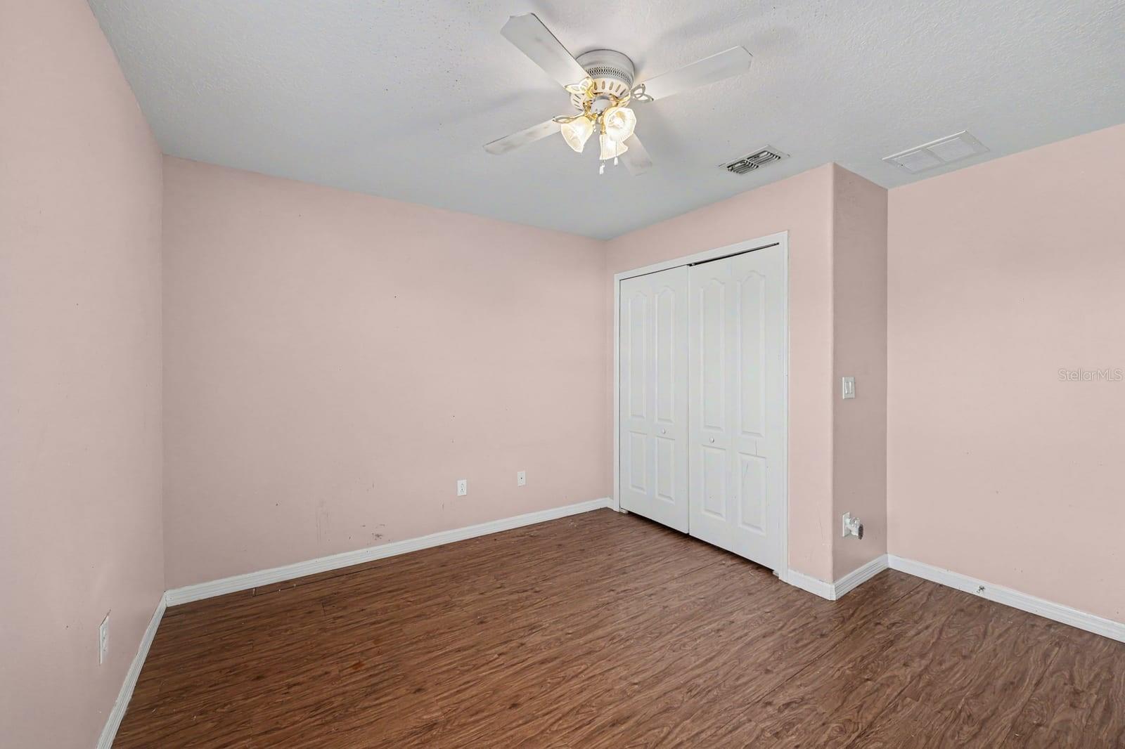 Generous Bedroom Space with Dual Closets, Wood Flooring & Fan