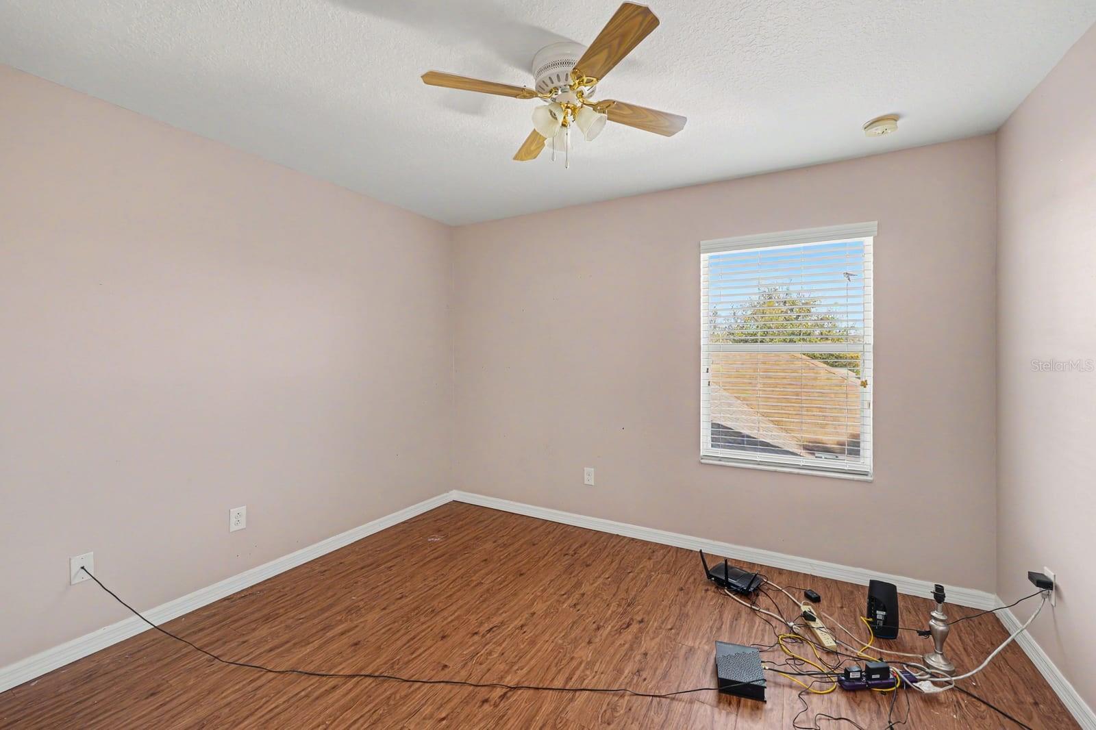 Secondary Bedroom With Pink Walls, Wood Floors & Ceiling Fan