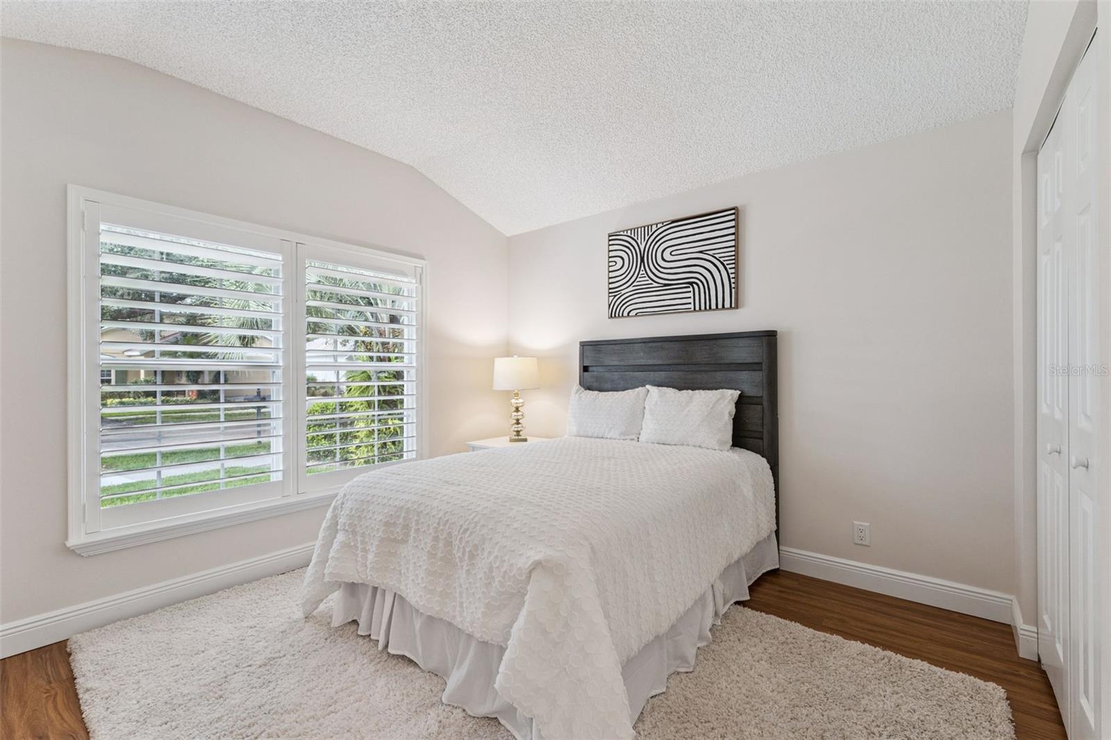 12' x 10'6" Bedroom #2 w/ laminate floor & Plantation style shutters