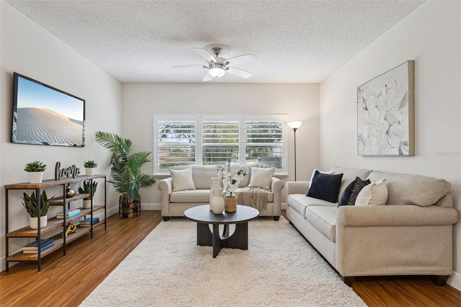 14' x 13' Family Room w/ laminate floor, ceiling fan & Plantation style shutters