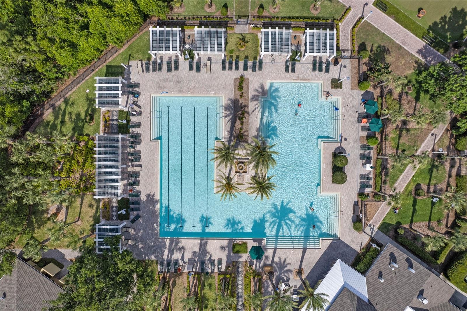 Aerial view above the Victoria Gardens resort style heated pool w/ shaded arbors around perimeter