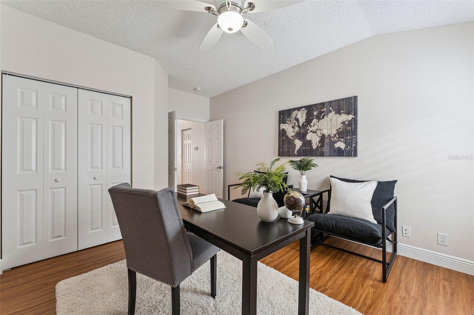 Bedroom #3 w/ a laminate floor, double door entry & a ceiling fan