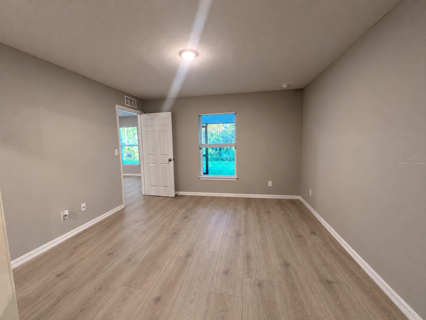 Primary bedroom reverse angle  virtually staged: planned laminate flooring.