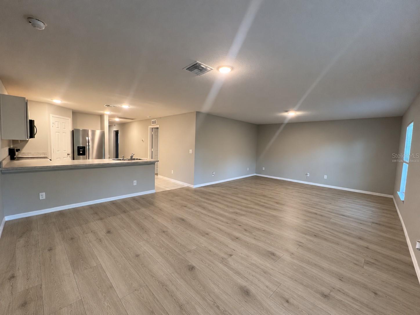 Living room and kitchen virtually staged: planned laminate flooring. Living room and kitchen virtually staged: planned laminate flooring.