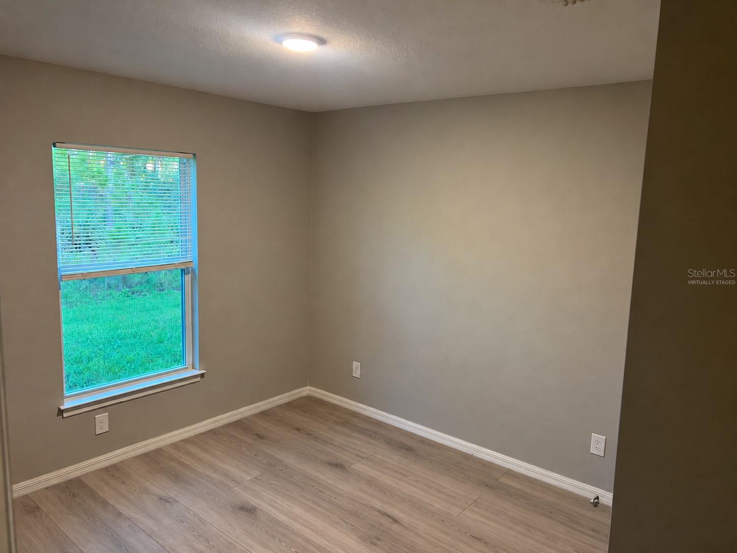 Bedroom 2  virtually staged: planned laminate flooring.