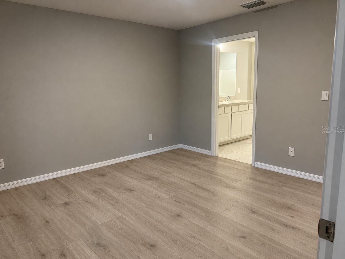 Primary bedroom  virtually staged: planned laminate flooring.