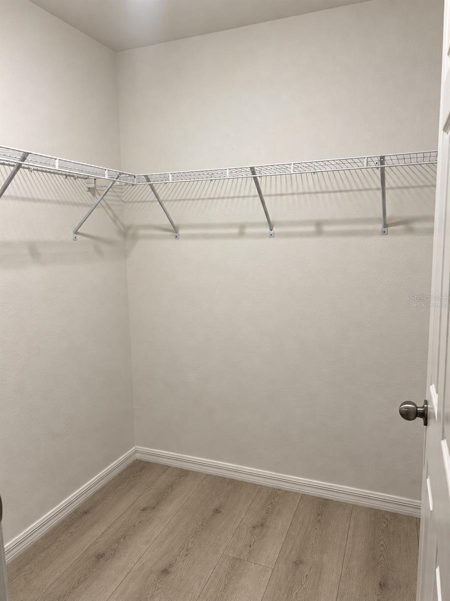 Walk-in closet  virtually staged: planned laminate flooring.