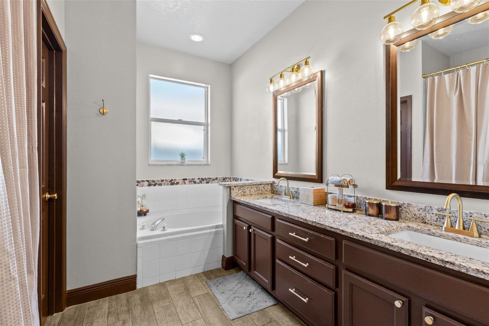 Primary bathroom with double vanity, soaking tub, walk-shower and toilet closet.