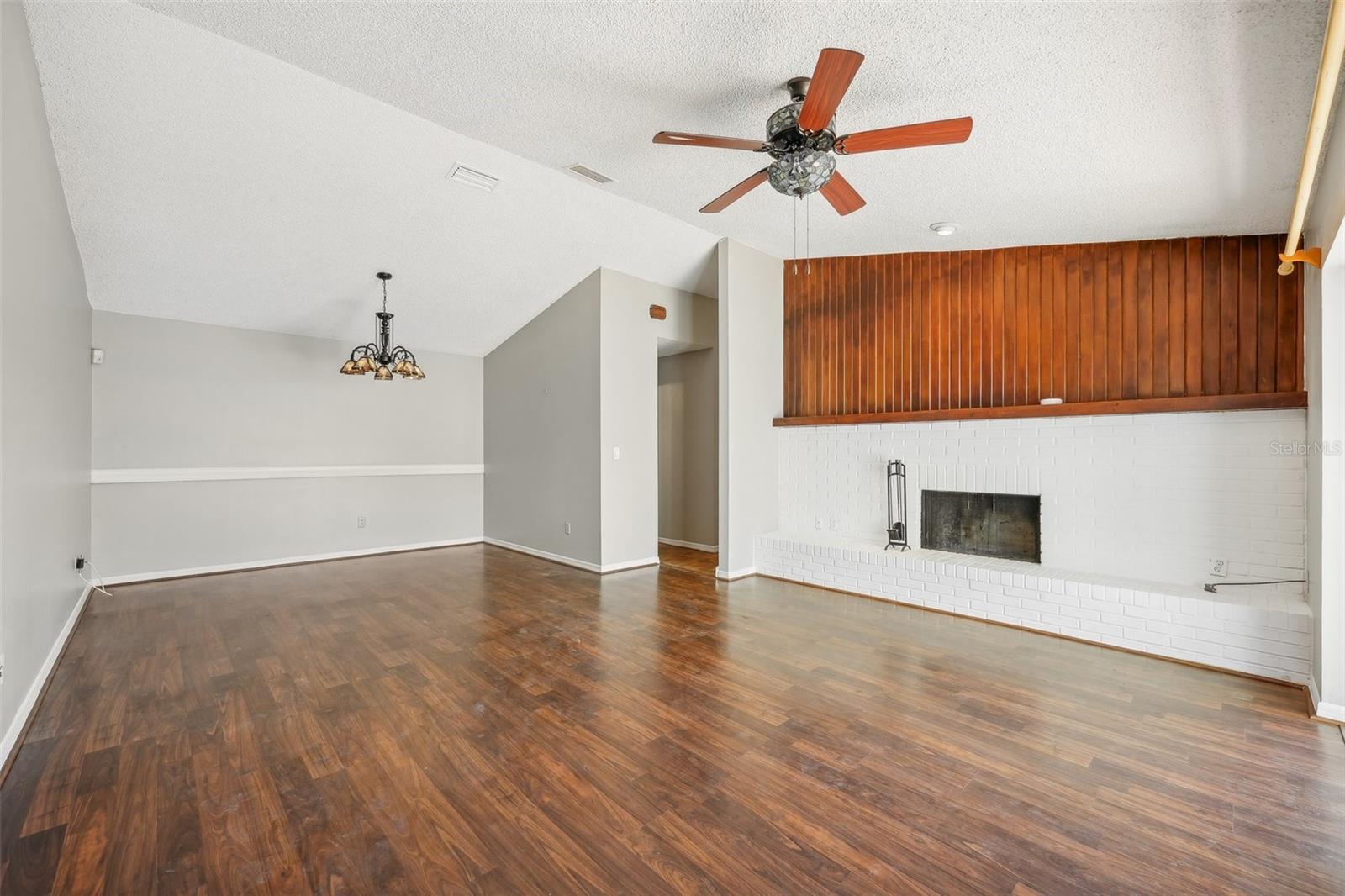 Spacious living room with a wood-burning fireplace, separate dining room with laminate floors.