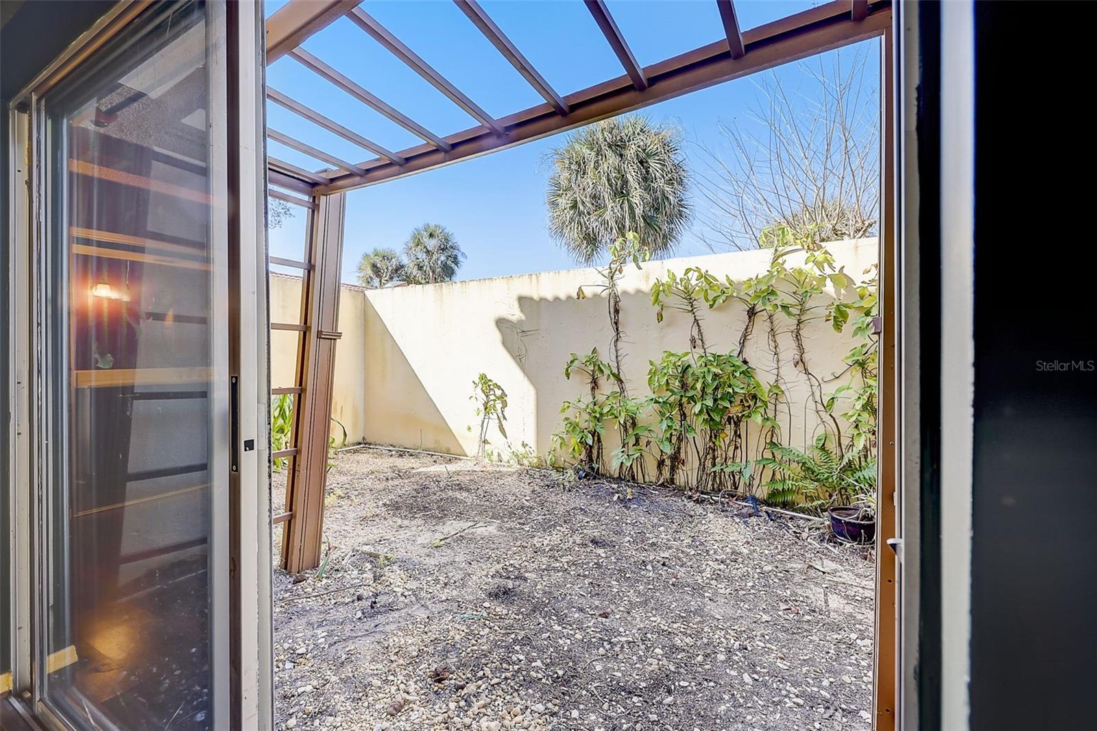 The downstairs primary suite offers a private, walled courtyard.
