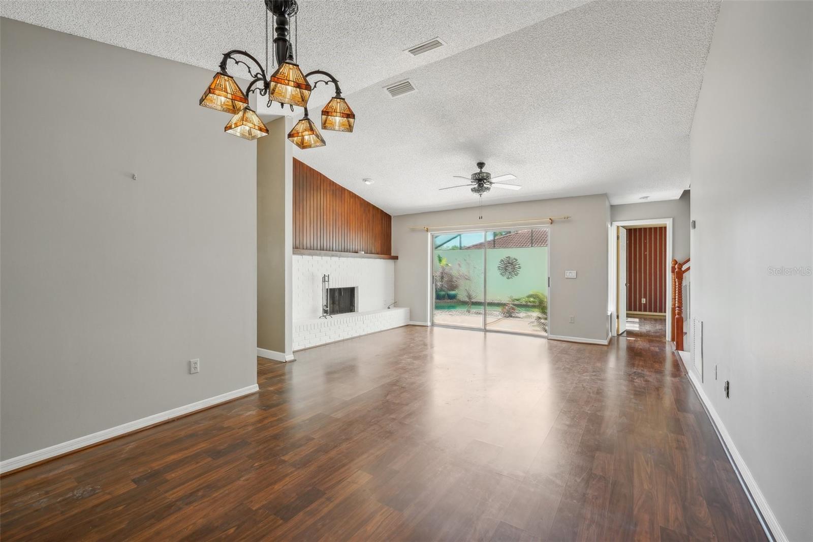 Spacious living room with a wood-burning fireplace, a separate dining room and laminate floors.