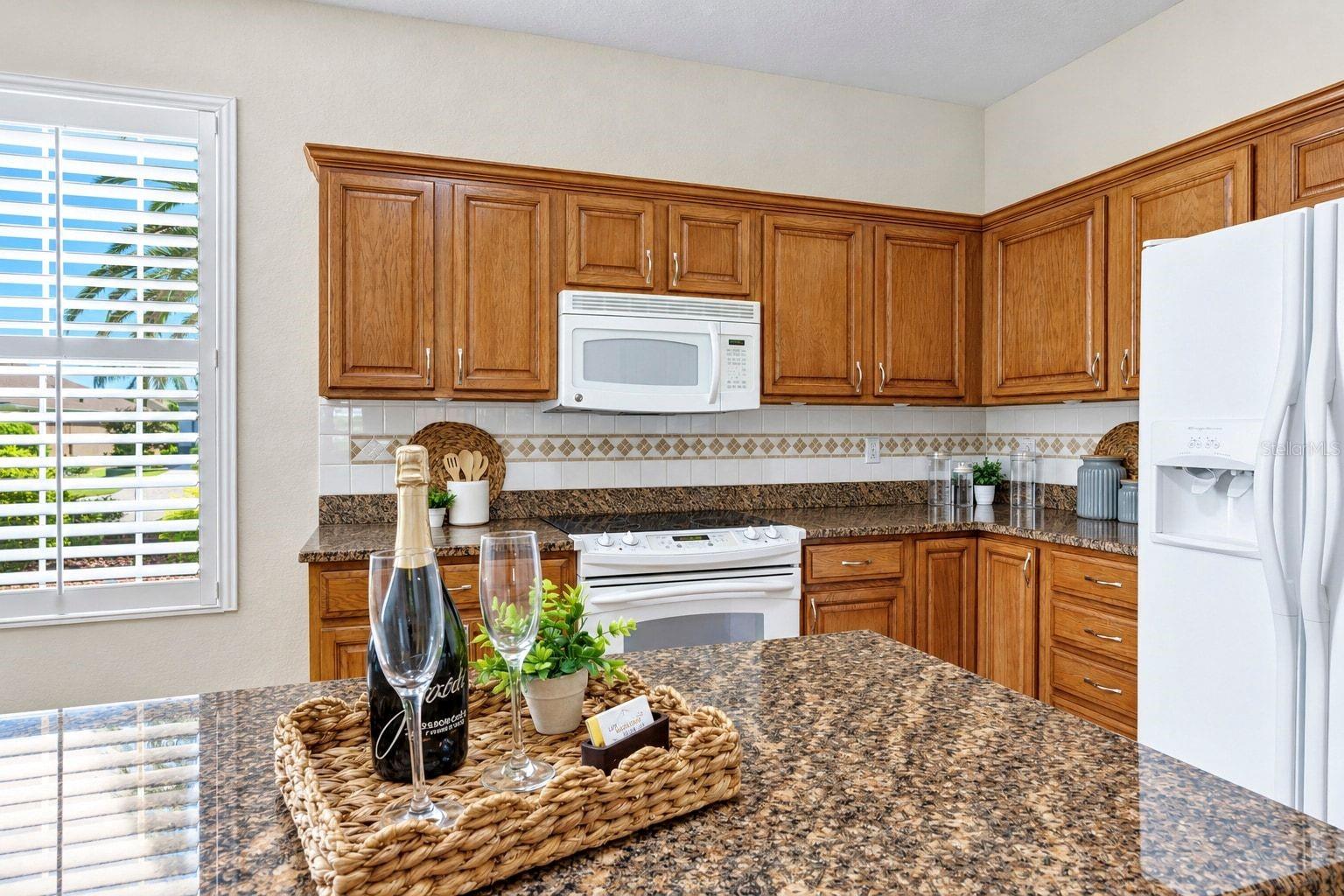 Classic wood cabinetry and granite countertops create a warm, practical kitchen with timeless appeal.