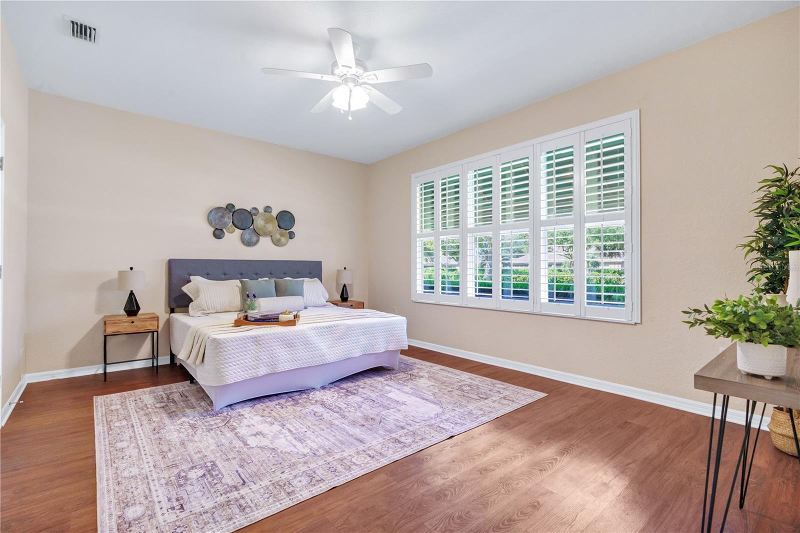 Spacious primary suite featuring beautiful flooring, natural light, and a relaxing atmosphere.