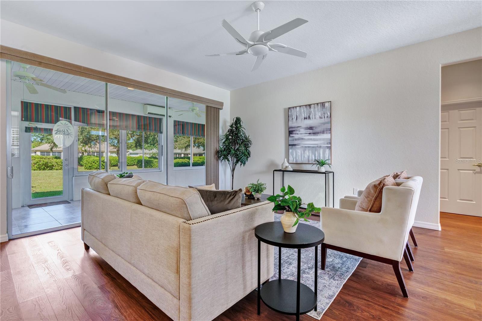 Welcoming living area with abundant windows and views toward the enclosed lanai