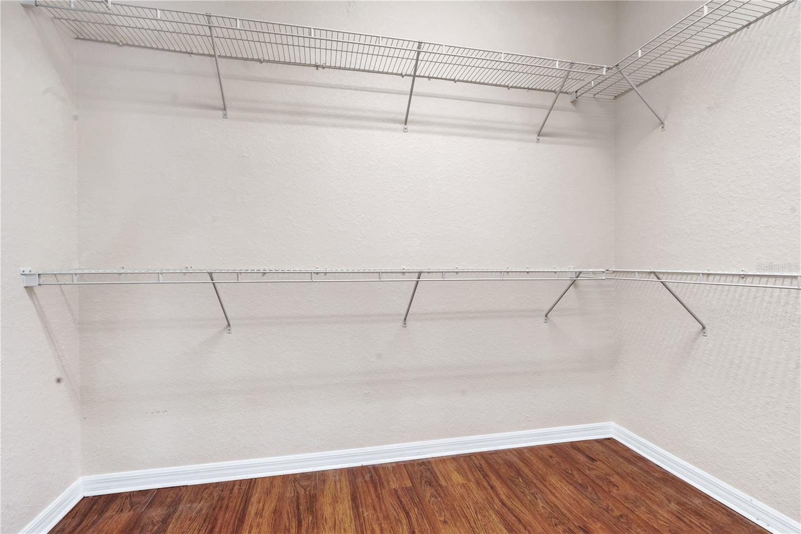 Generous walk-in closet with built-in shelving and hanging space for organized storage.