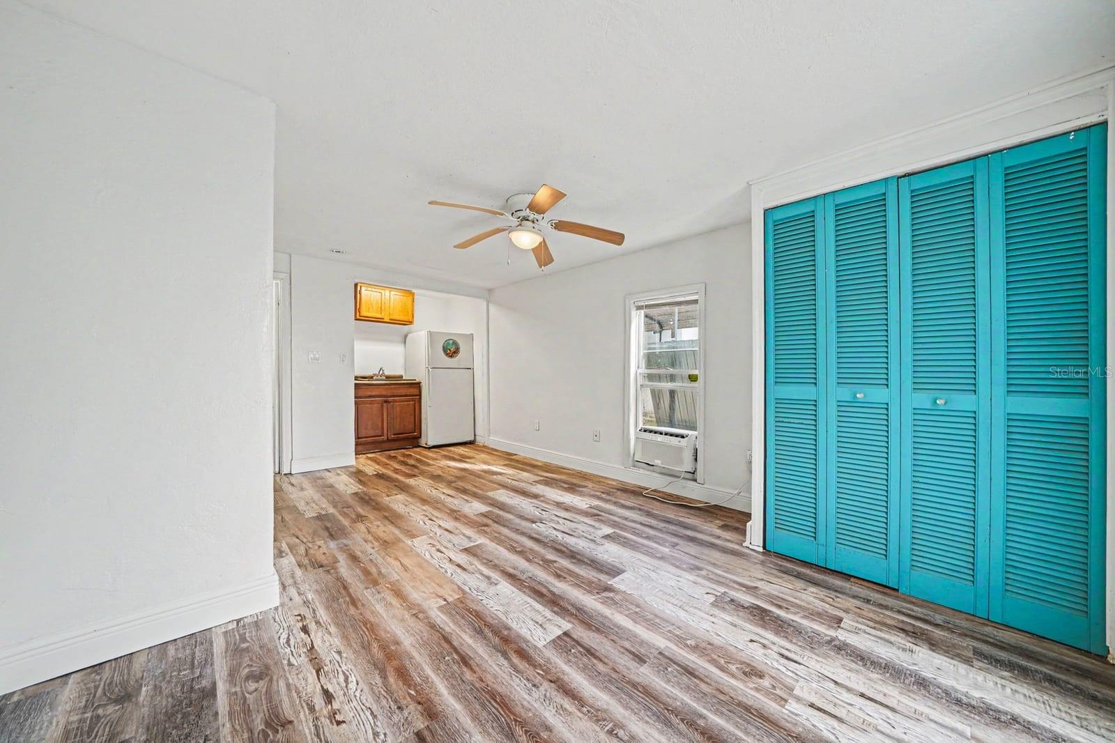 Bright Bedroom with Turquoise Closets, Wood Floors & Multiple Windows