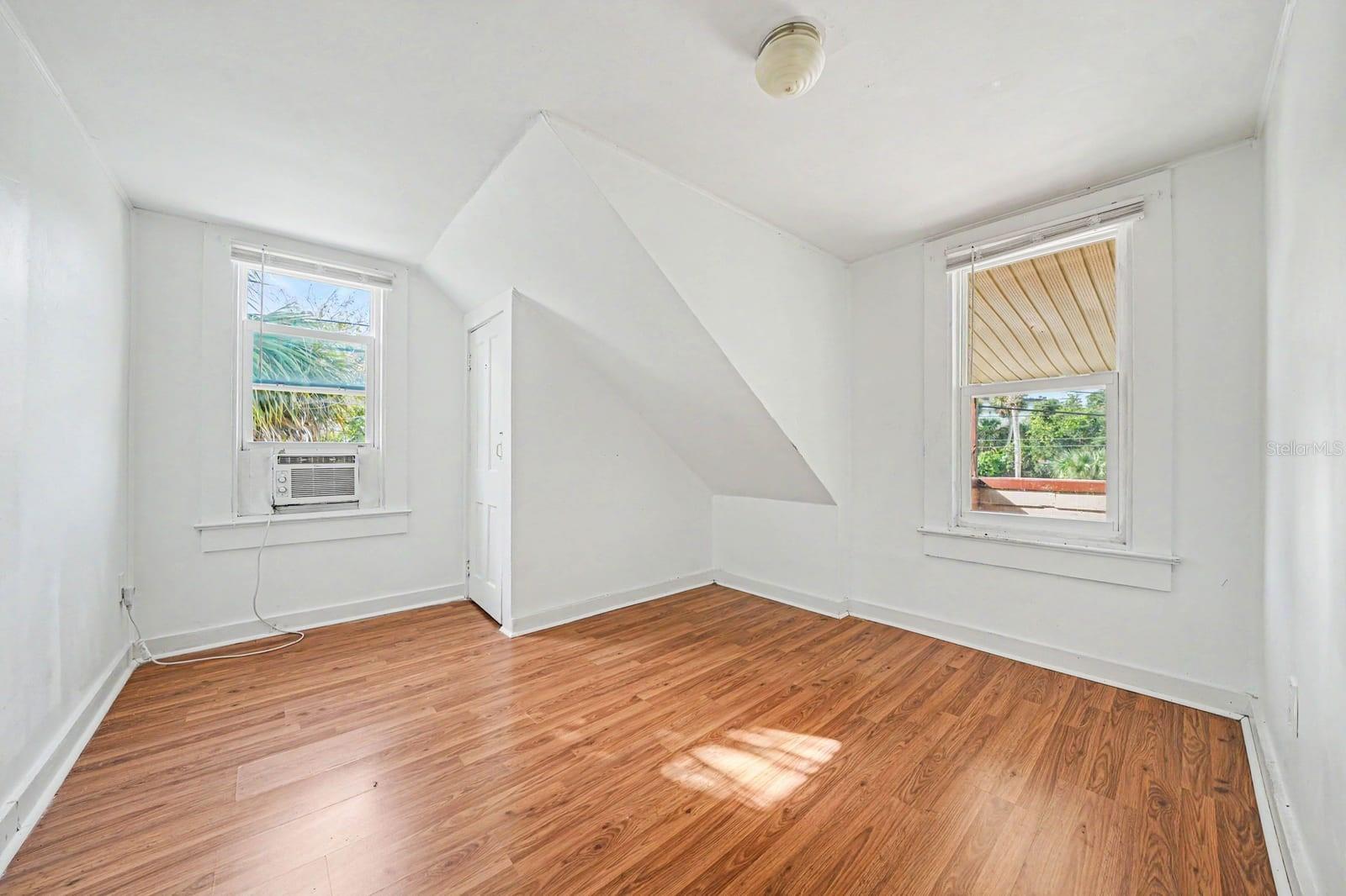 Attic Bedroom with Window AC Unit, Two Windows & Wood Flooring
