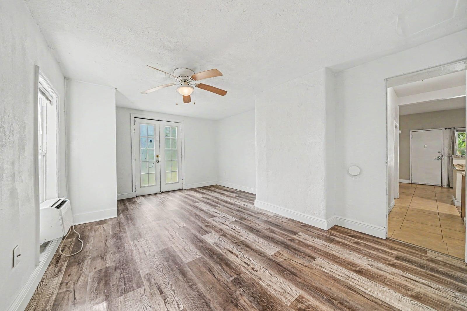 Spacious Living Area with Wood Floors, French Doors & Ceiling Fan
