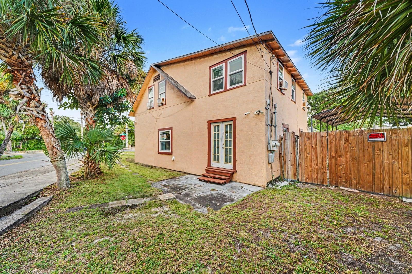 Front Exterior with Palm Trees, Landscaping & Wooden Fence Gate