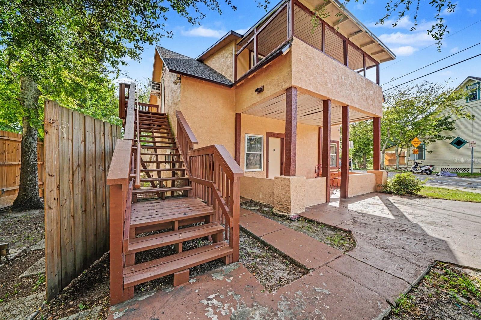Elevated Home With Red Wooden Stairs & Ground-Level Access Elevated Home With Red Wooden Stairs & Ground-Level Access