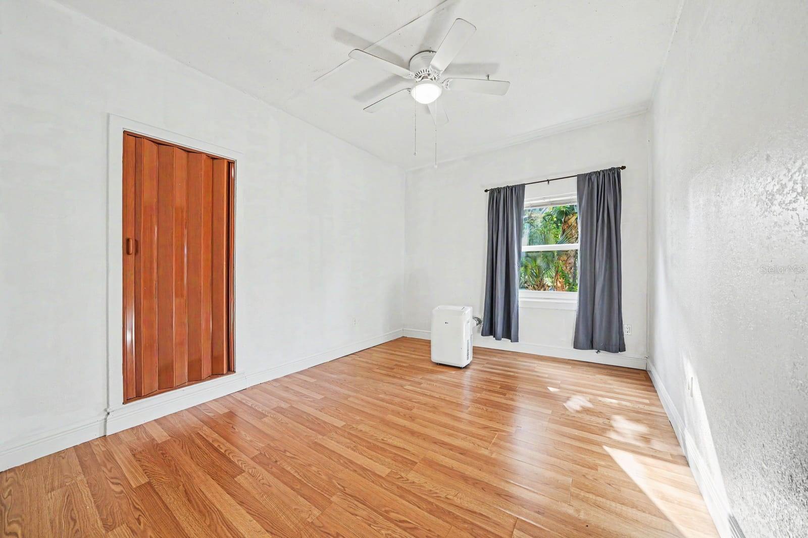 Bedroom with Hardwood Floors, Ceiling Fan & Window with Landscape Views