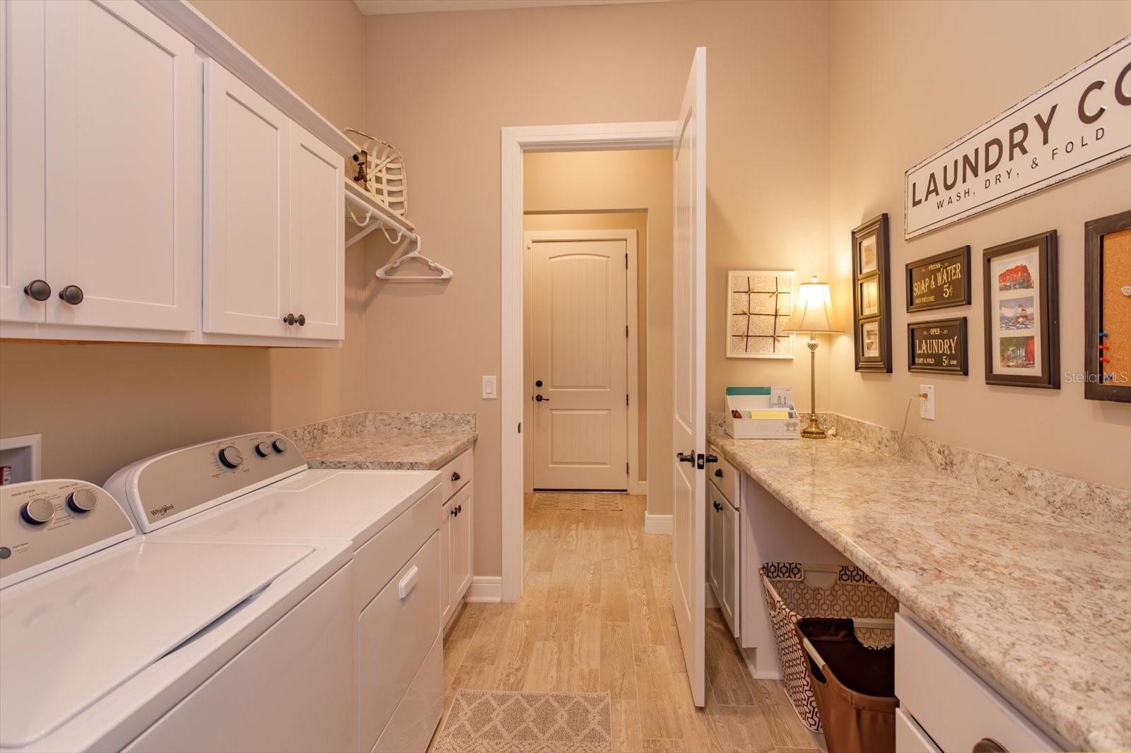 From the Closet or Hallway you can access the Laundry Area with Ample Storage and Countertops for Folding Laundry, Crafts or Projects.
