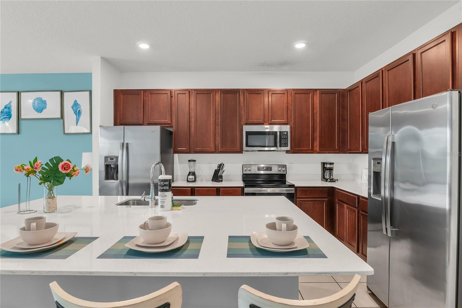 Kitchen with double refrigerator and stainless steel appliances