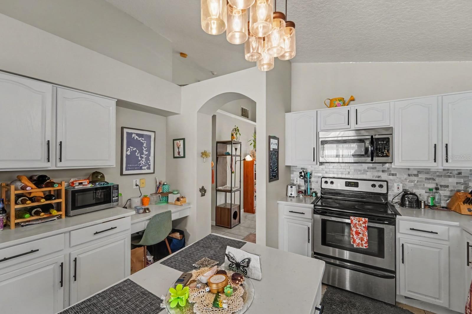 Chef's Kitchen with White Cabinetry, Stainless Steel Appliances & Island Workspace Chef's Kitchen with White Cabinetry, Stainless Steel Appliances & Island Workspace