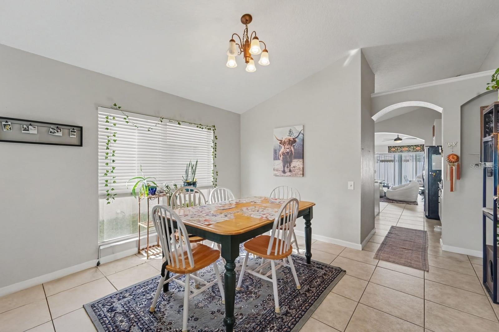 Dining area features arched doorway connecting to kitchen and family spaces Dining area features arched doorway connecting to kitchen and family spaces