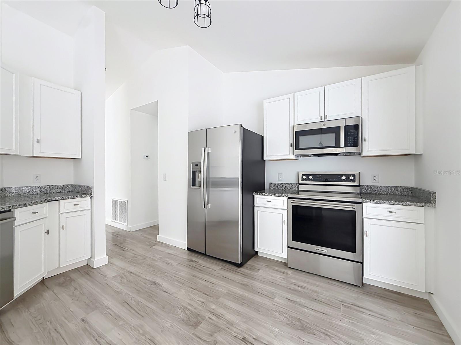 Stainless steel appliances elevate the bright kitchen.