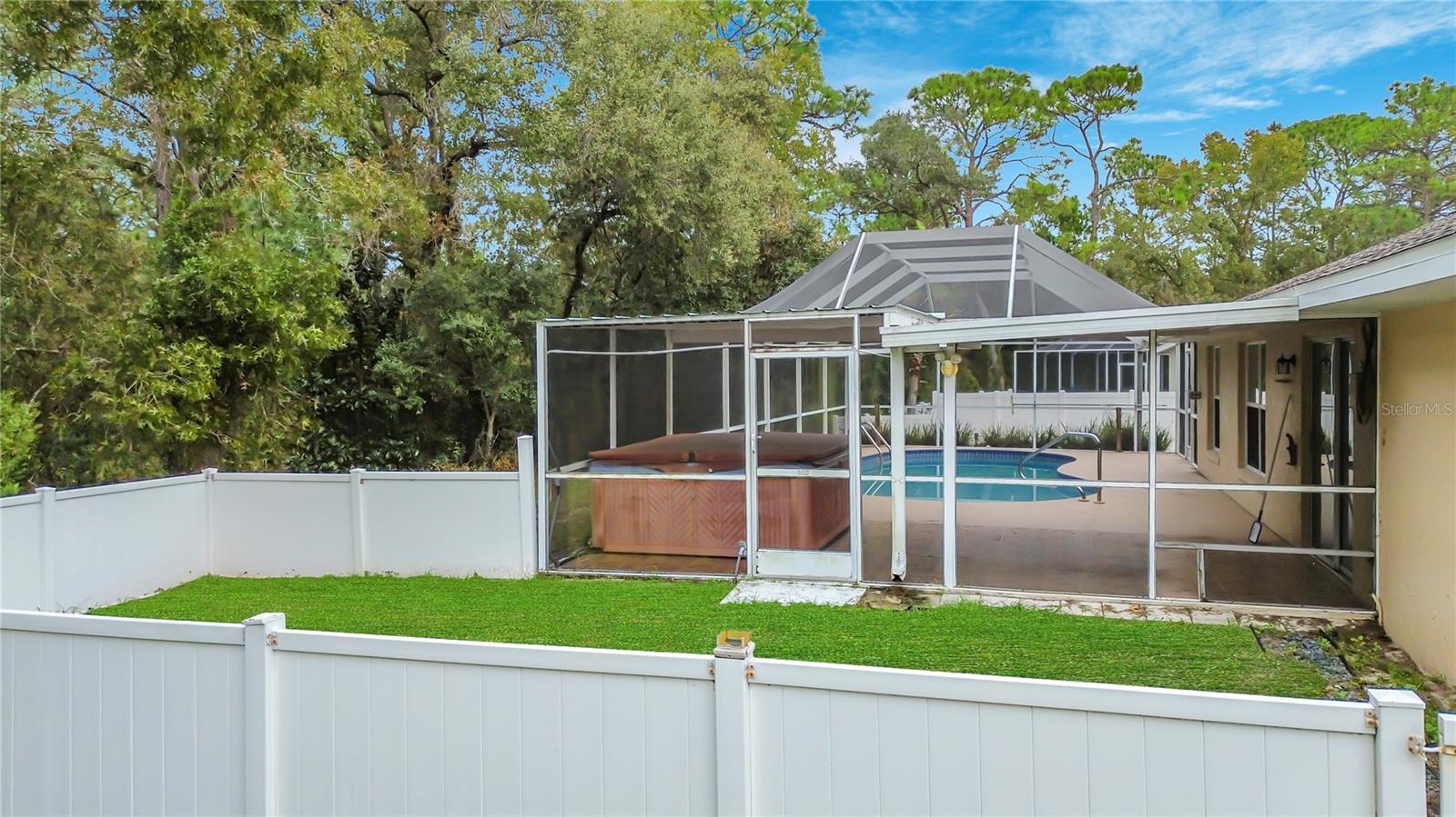 A fenced side yard beside your screened pool retreat.