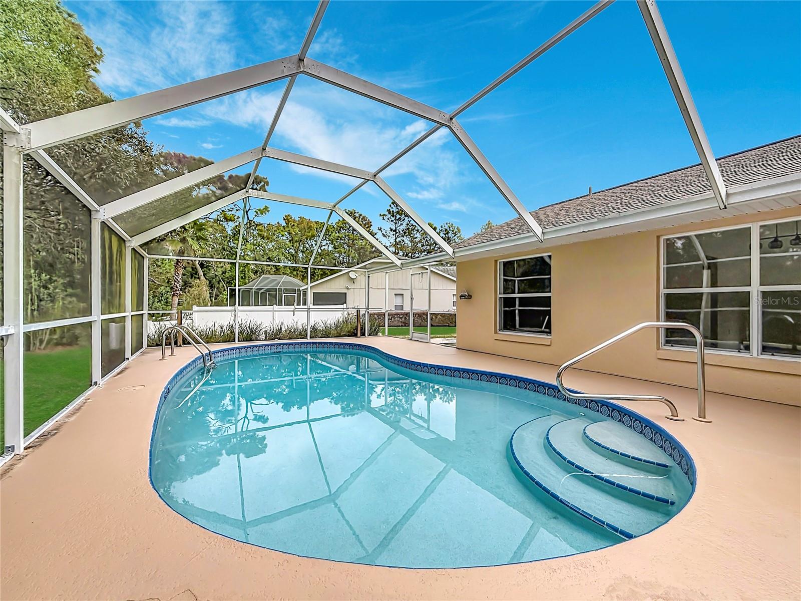Take a refreshing dip in your screened backyard pool.