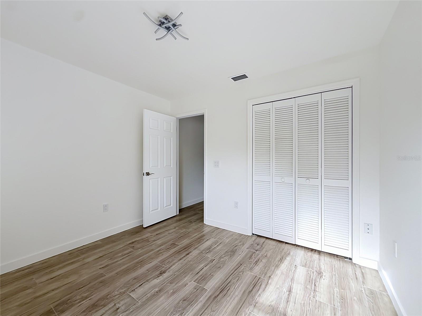 Wood-look flooring creates a warm, inviting bedroom.