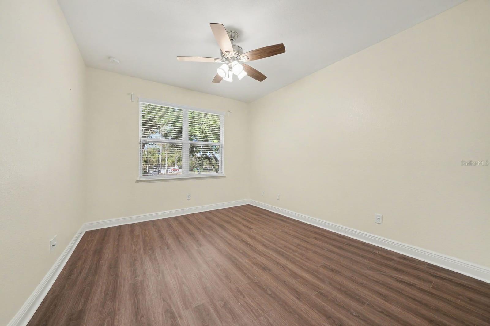 Spacious Bedroom with Hardwood Floors, Ceiling Fan & Natural Light