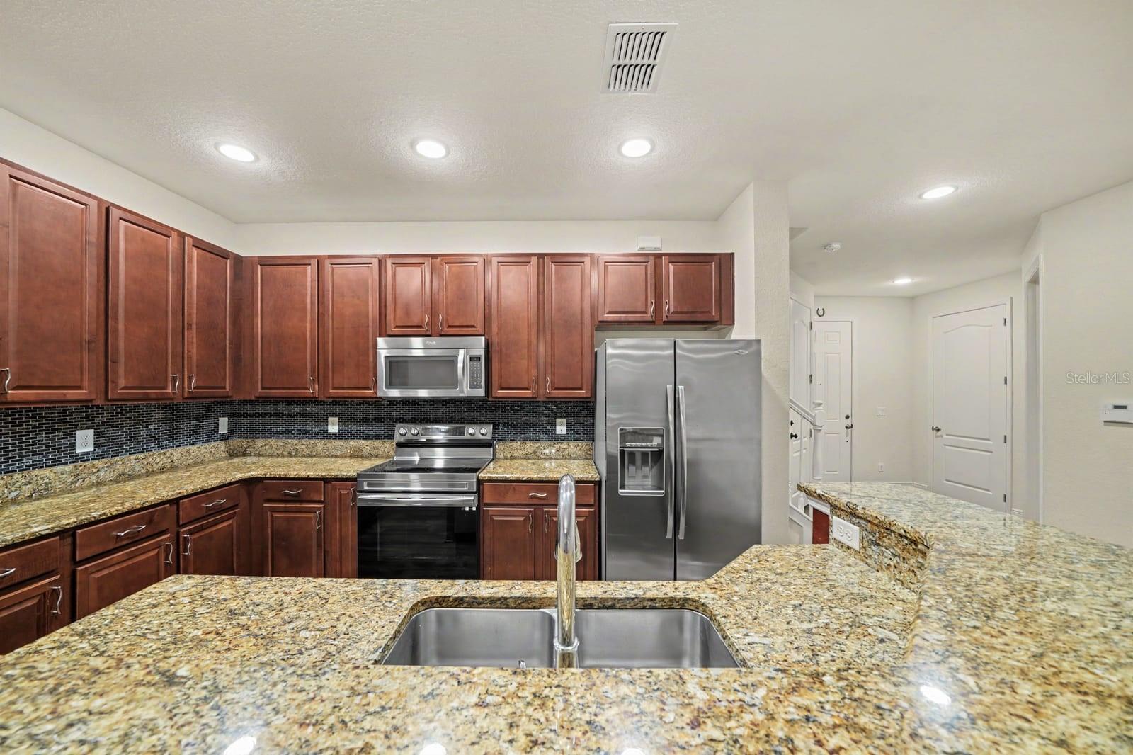 Chef's Kitchen Featuring Granite Countertops & Modern Stainless Steel Finishes