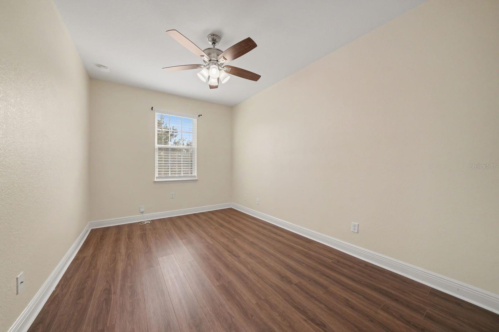 Comfortable Bedroom with Hardwood Floors, Ceiling Fan & Window View