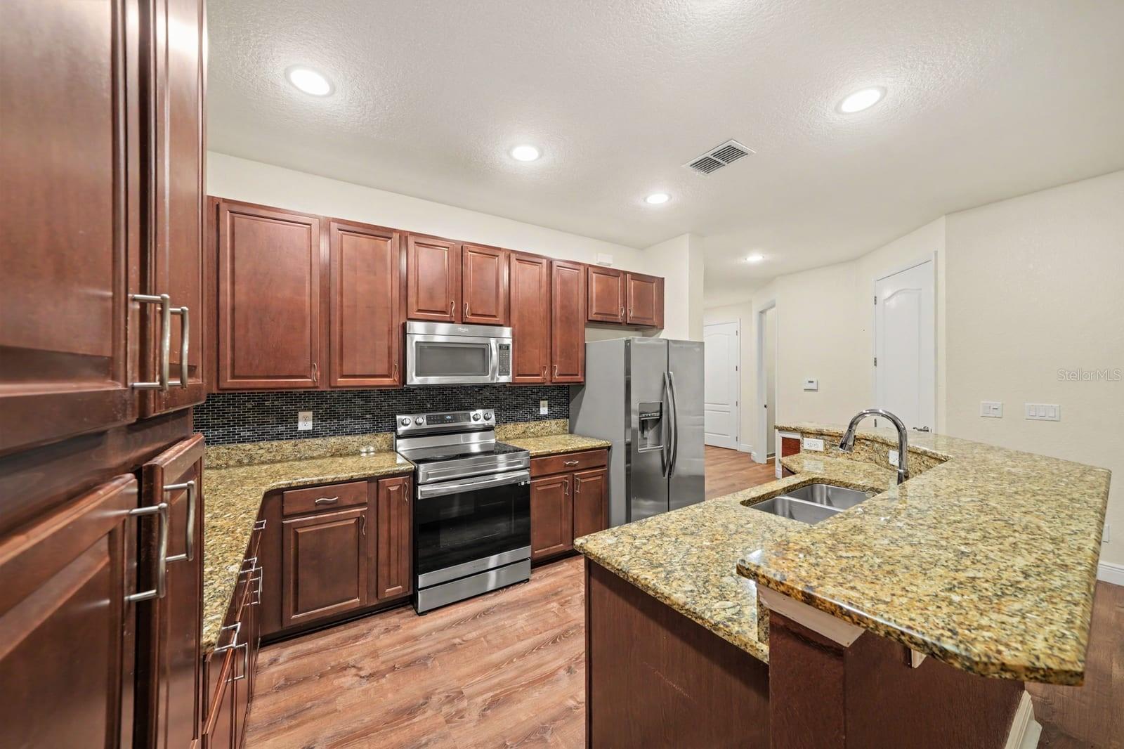 Well-Appointed Kitchen With Ample Granite Countertop Space & Island