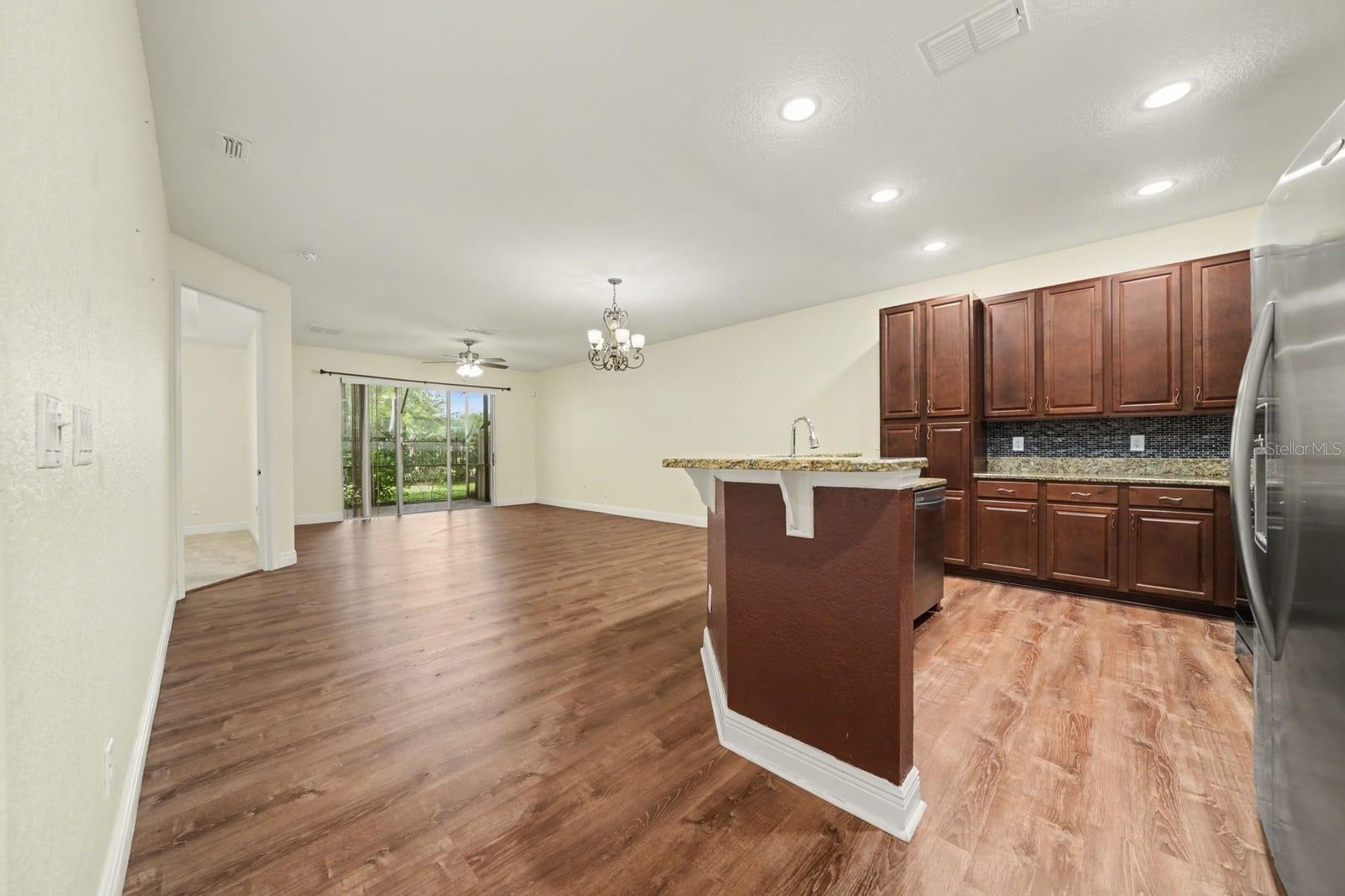 Gourmet Kitchen With Dark Cabinetry, Stainless Steel, And Island Workspace