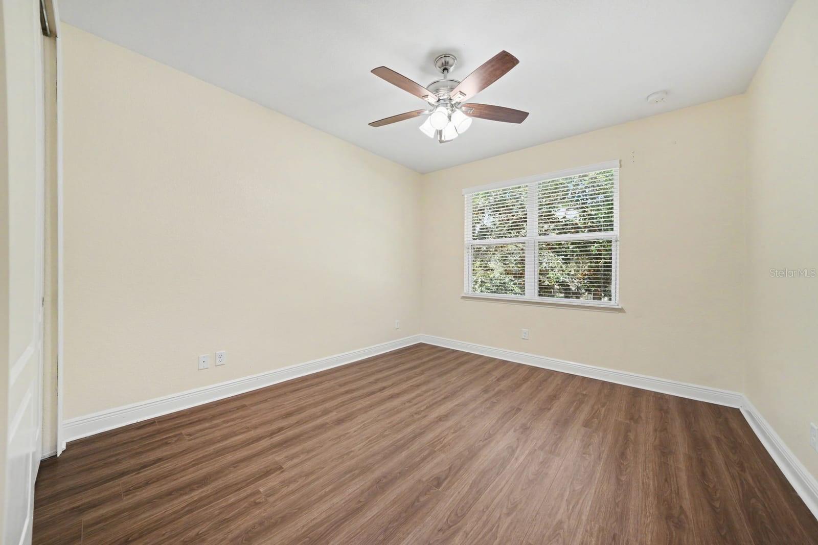 Secondary Bedroom Features Wood Flooring, Ceiling Fan & Bright Windows