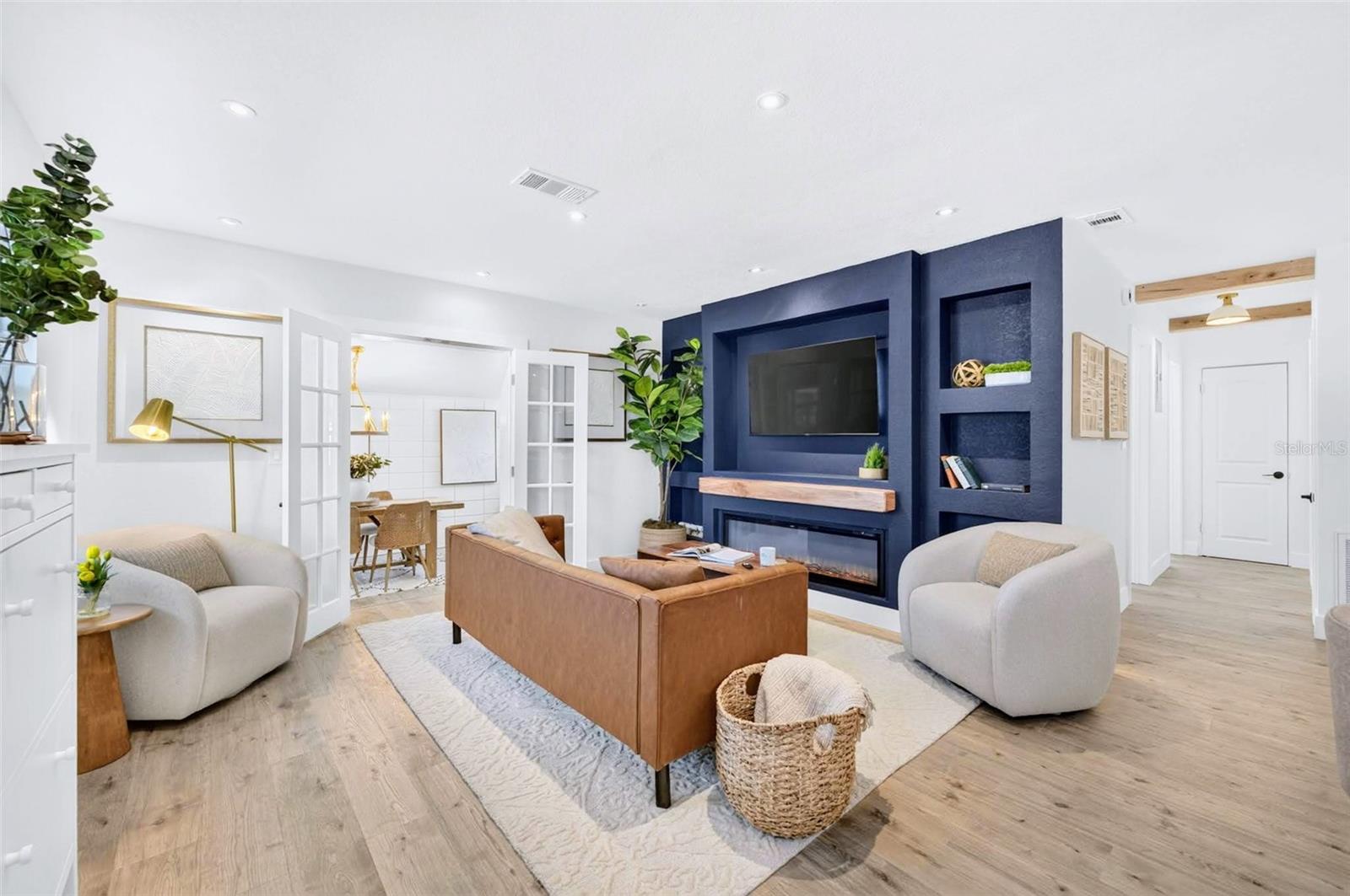 upon entry your greeted with warm floors and a blue splash of color on the entertainment wall.