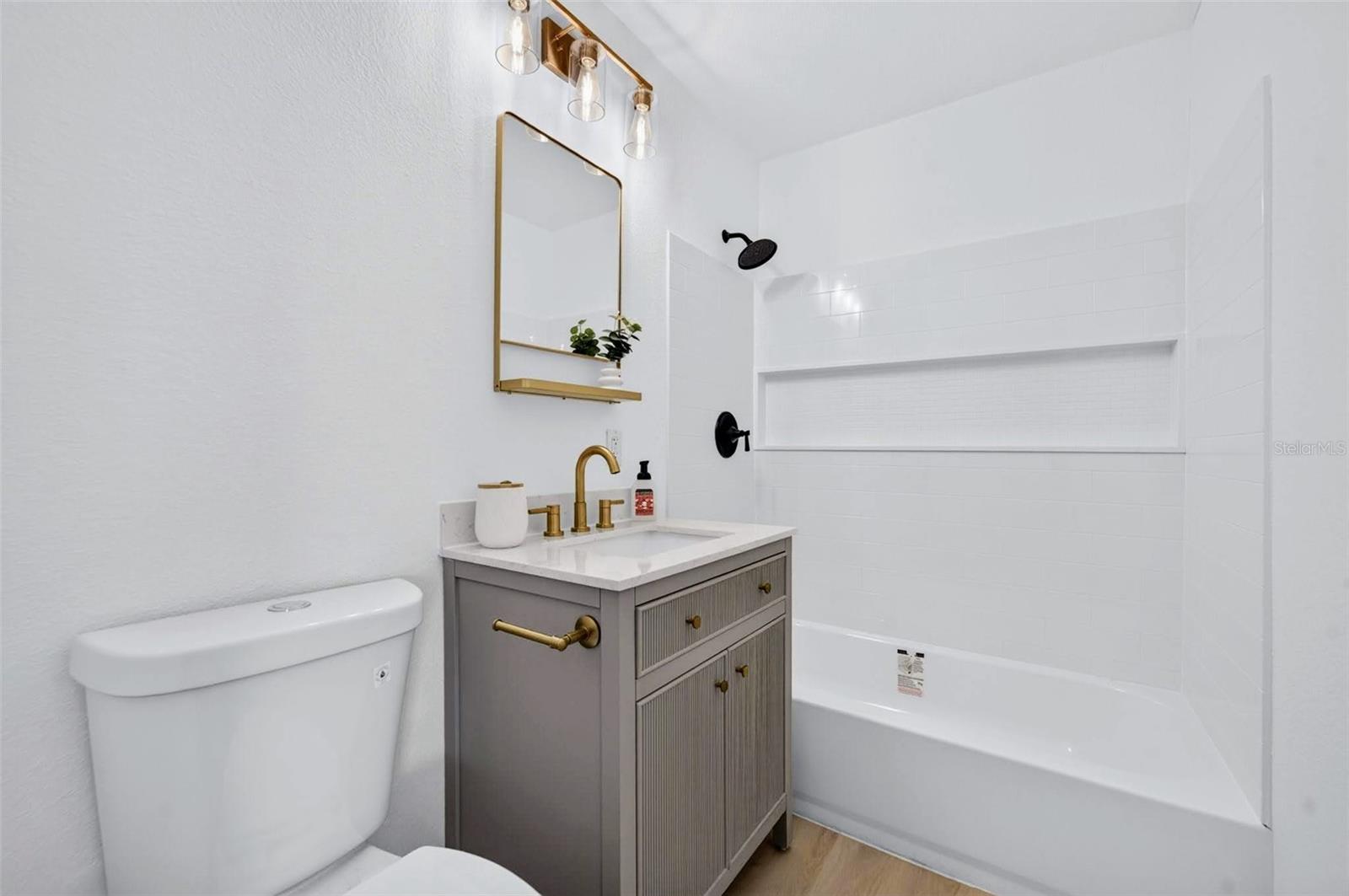 This bathroom has the easy to clean/maintain shower surround, with the shelf for multiple bottles of shampoo and hair products.