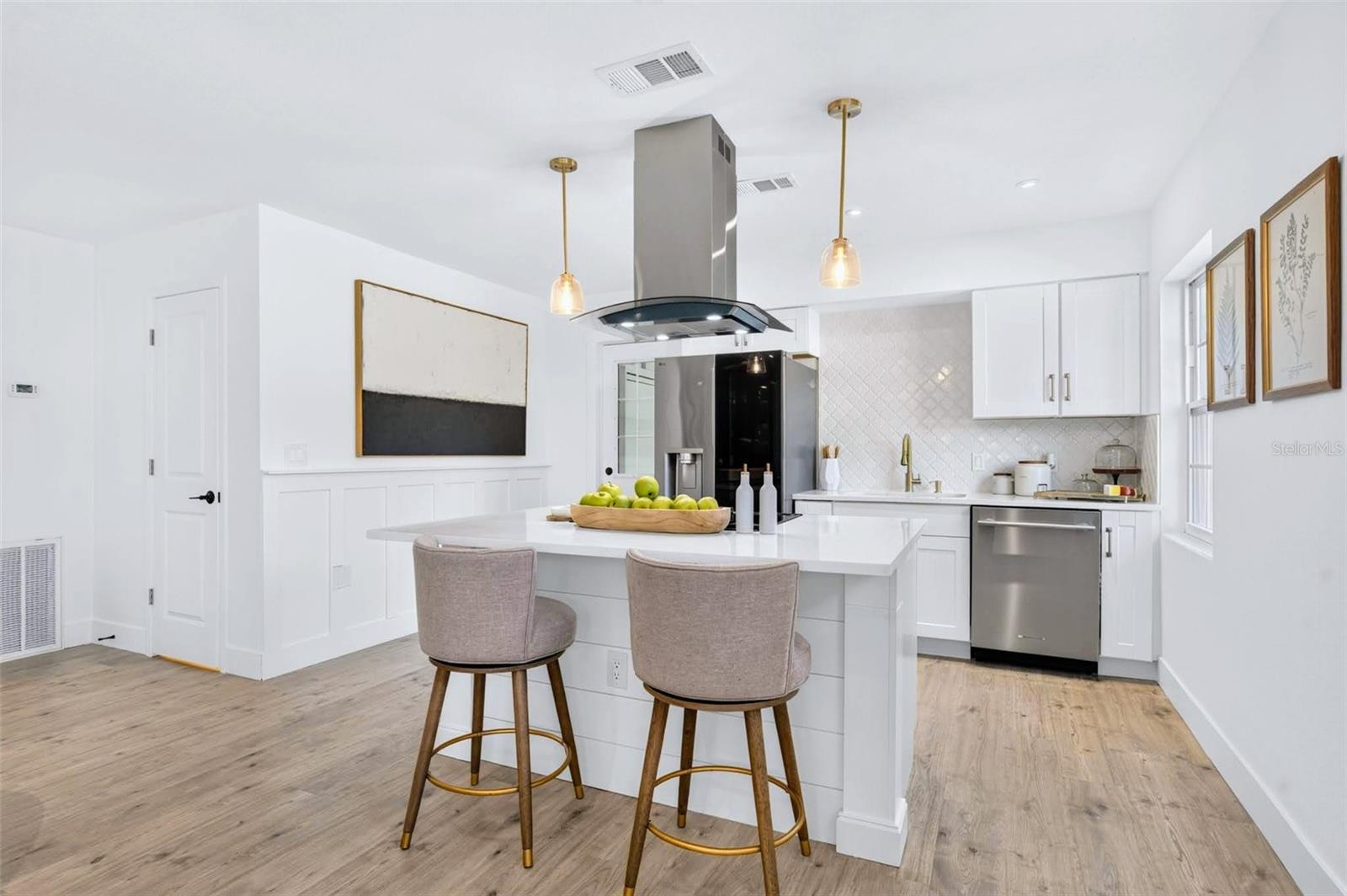 the Kitchen boasts a island stove with a vent hood and custom columns for the island ends.