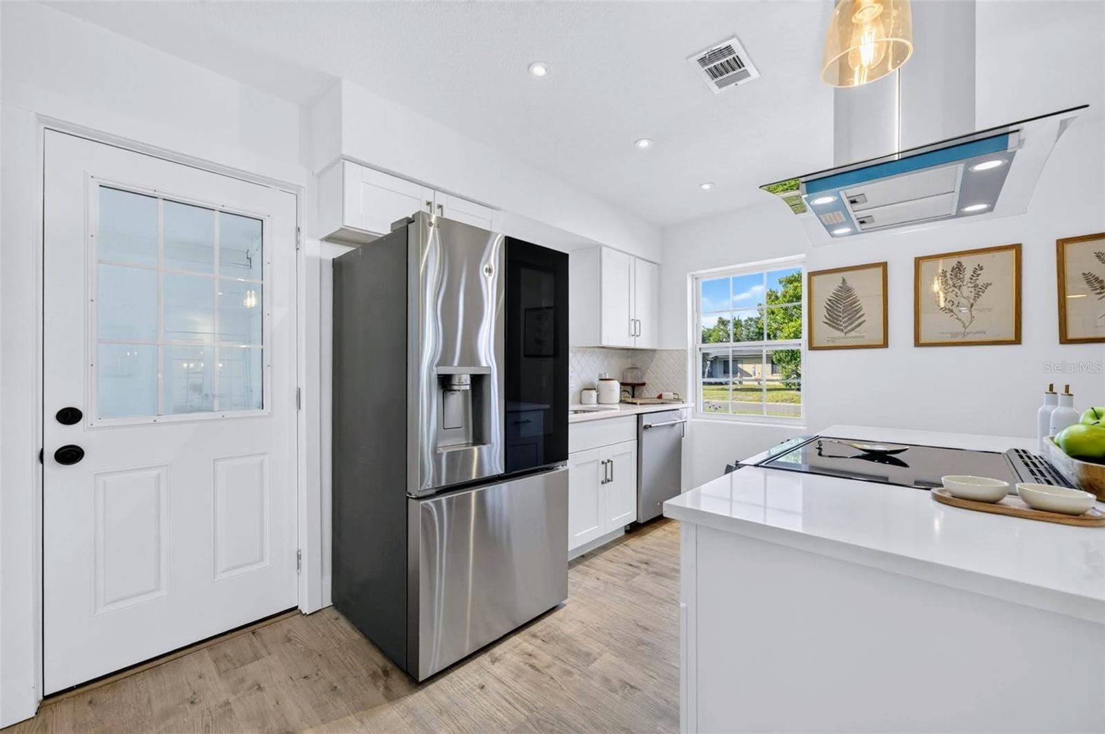 The High end fridge features a see through glass door with an ability to knock on the door to turn on the light of the fridge to see what is stored in the glass panel.