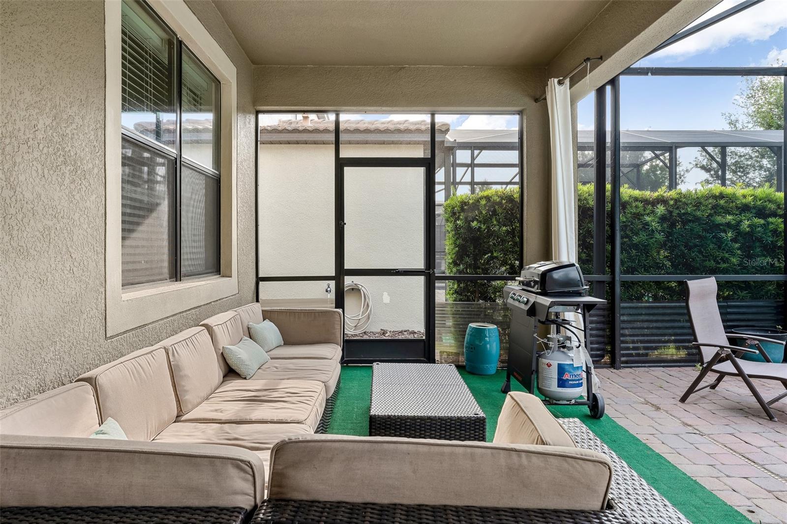 Covered Lanai with Comfortable Outdoor Seating and Direct Access to the Pool