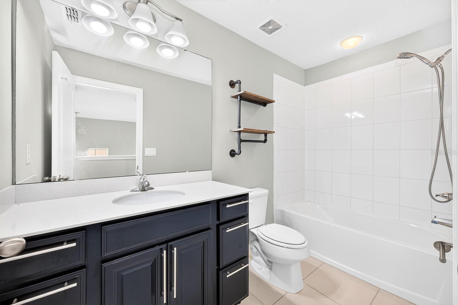 The upstairs full Bath continues the home's stylish finishes, featuring a QUARTZ COUNTERTOP that complements the matching countertops in both main-floor Bathrooms.